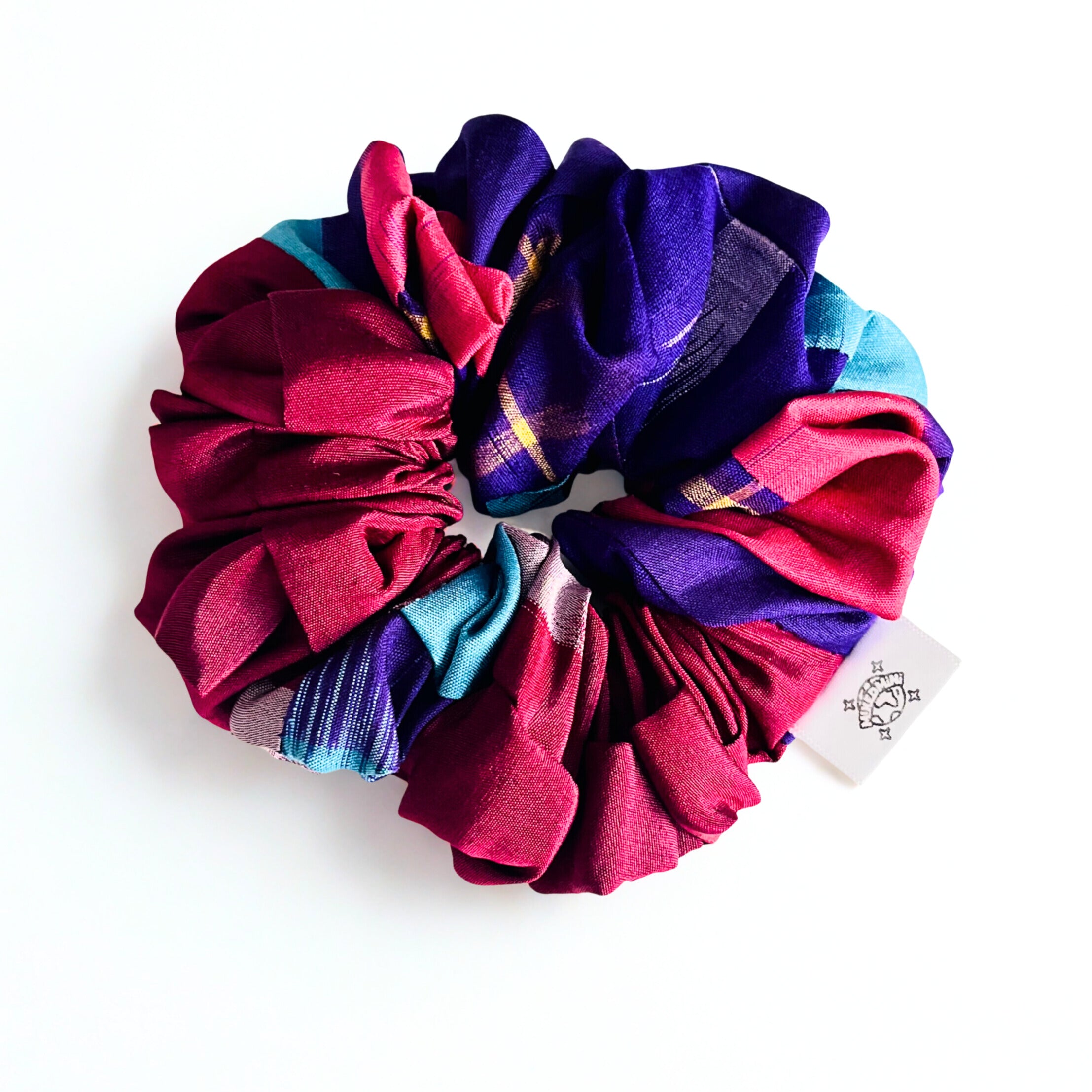 Scrunchie made from upcycled kimono fabric in mixed bright colors with a small logo tag