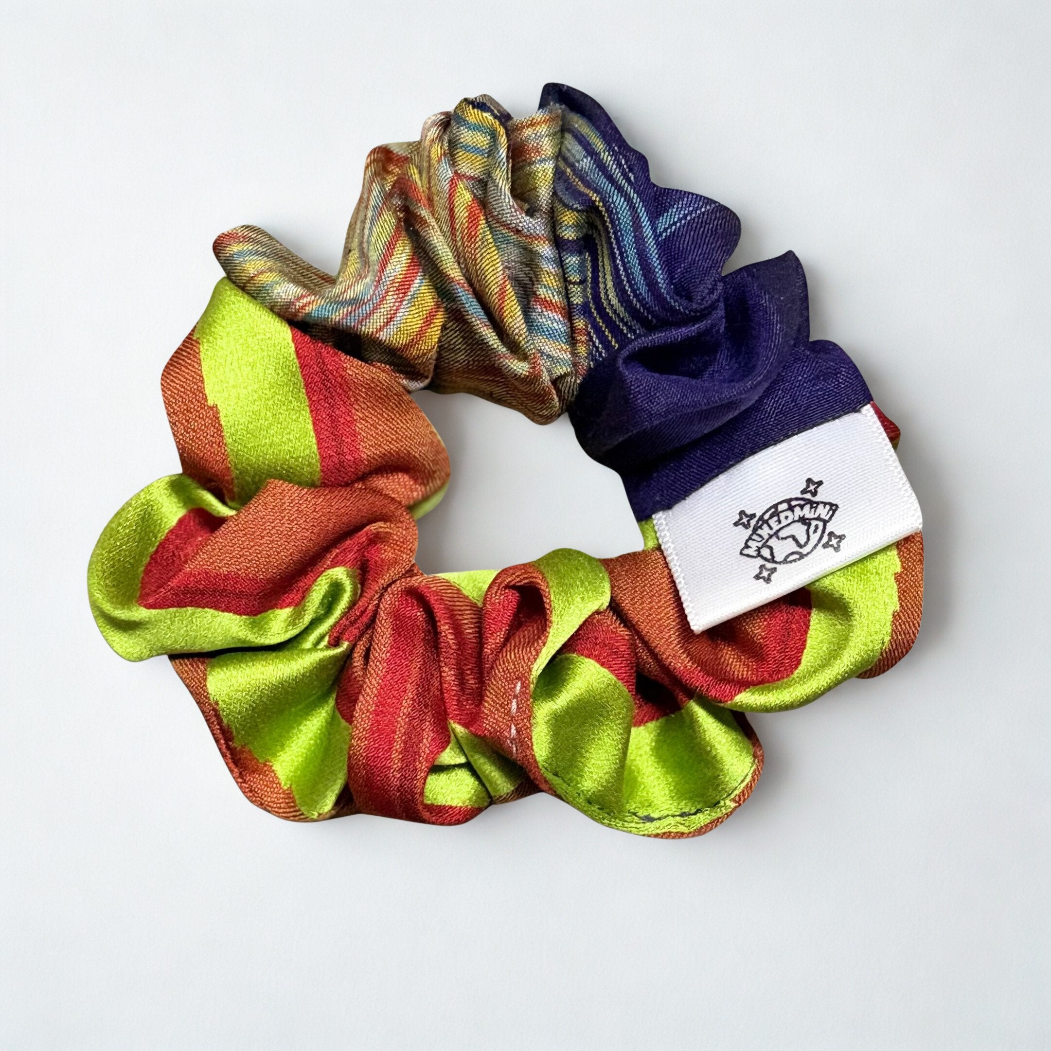Scrunchie made from upcycled kimono fabric in mixed bright colors with a small logo tag
